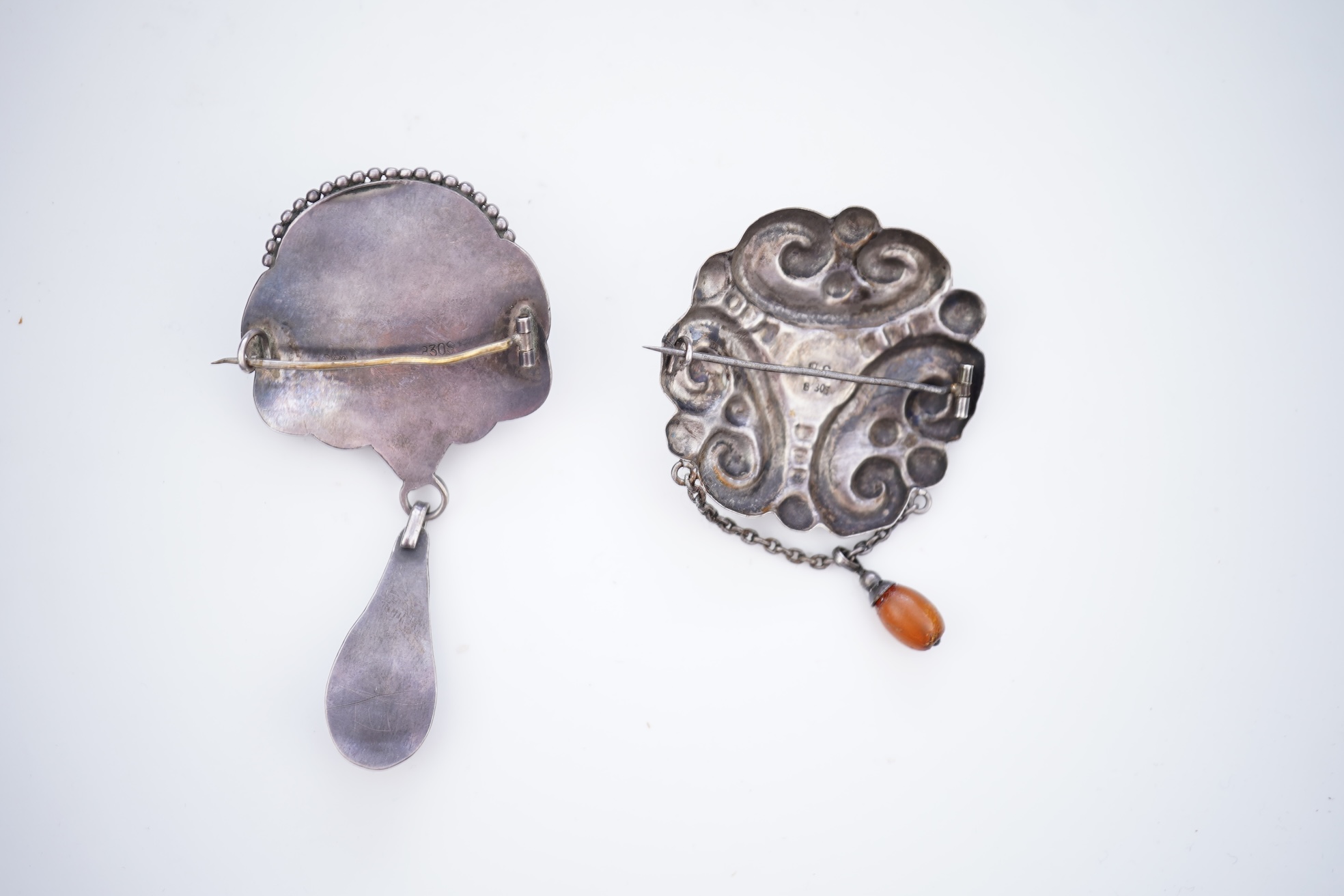 Two Arts & Crafts silver and amber pendant brooches, probably Denmark, early 20th century